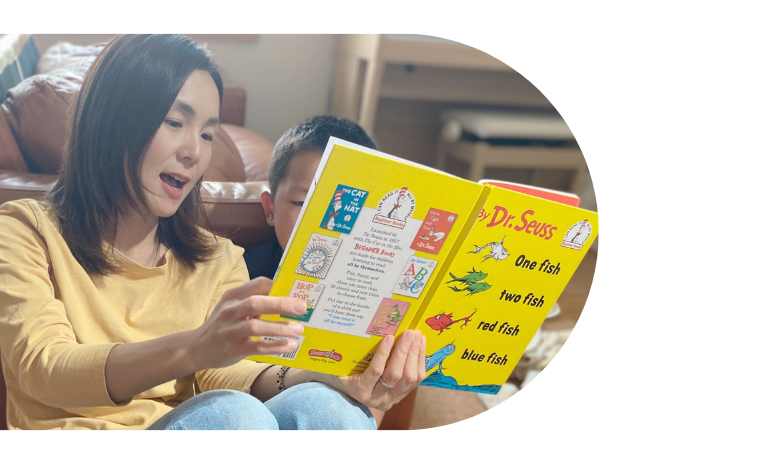 絵本を読み聞かせるお母さんと、隣で聞き入る男の子