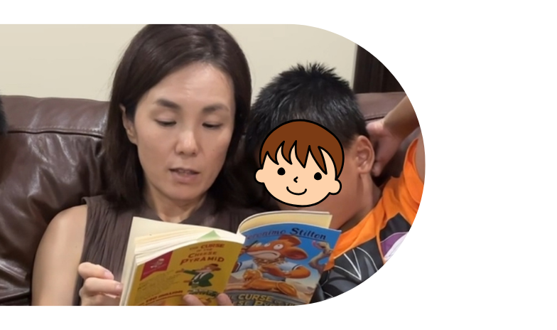 絵本を読み聞かせるお母さんと、隣で聞く男の子
